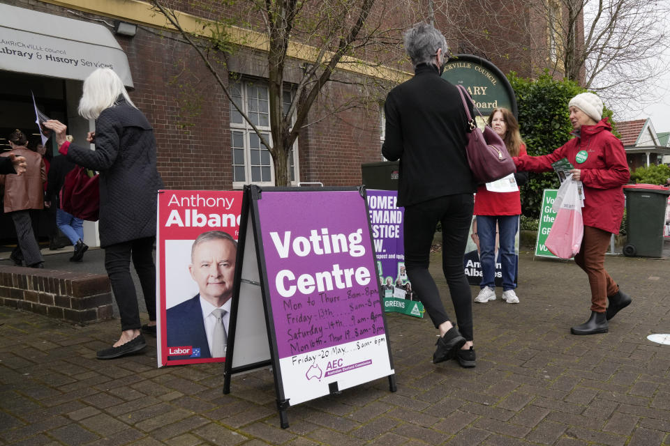 Voters walk into a pre-polling booth in Sydney, Australia, Friday, May 20, 2022. Australians will go to the polls Saturday following a six-week election campaign that has focused on pandemic-fueled inflation, climate change and fears of a Chinese military outpost being established less than 1,200 miles off Australia's shore. (AP Photo/Mark Baker)