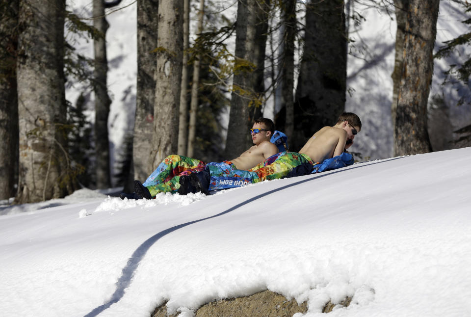 Two volunteers sunbathe next to the cross country ski and biathlon track, at the 2014 Winter Olympics, Wednesday, Feb. 5, 2014, in Krasnaya Polyana, Russia. (AP Photo/Kirsty Wigglesworth)