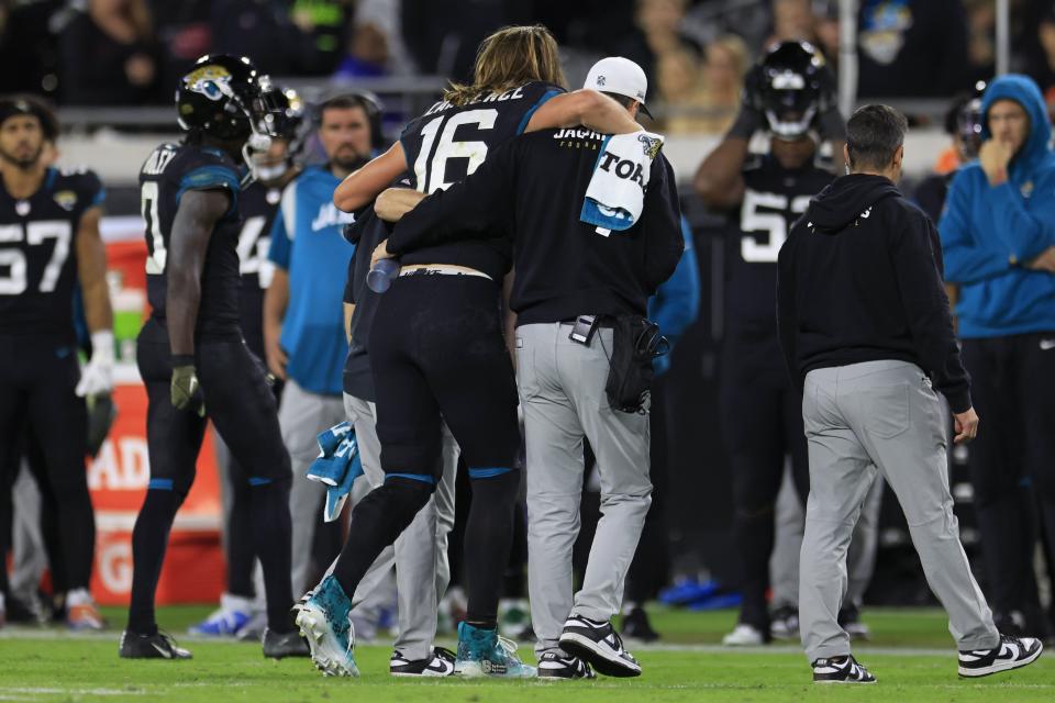 Jacksonville Jaguars quarterback Trevor Lawrence (16) is helped off the field after an apparent ankle injury that had him leave the game during the fourth quarter of a regular season NFL football matchup Monday, Dec. 4, 2023 at EverBank Stadium in Jacksonville, Fla. The Cincinnati Bengals defeated the Jacksonville Jaguars 34-31 in overtime. [Corey Perrine/Florida Times-Union]