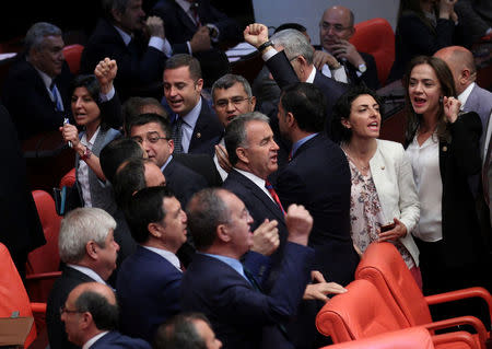 MPs of Turkey's main opposition Republican People's Party (CHP) shout slogans as they left a debate to protest the Parliament Speaker Ismail Kahraman who said overwhelmingly Muslim Turkey needed a religious constitution at the Turkish parliament in Ankara, Turkey, May 20, 2016. REUTERS/Umit Bektas