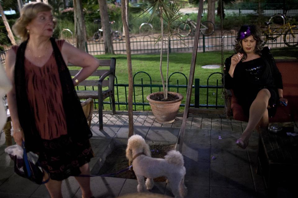 In this photo taken on Sunday, June 2, 2013, Israeli Orthodox Jew Shahar Hadar, right, rests between two shows outside a drag queen school in downtown Tel Aviv, Israel. Hadar, a telemarketer by day, has taken the gay Orthodox struggle from the synagogue to the stage, beginning to perform as one of Israel’s few religious drag queens. His drag persona is that of a rebbetzin, a female rabbinic advisor, a wholesome guise that stands out among the sarcastic and raunchy cast of characters on Israel’s drag queen circuit. (AP Photo/Oded Balilty)