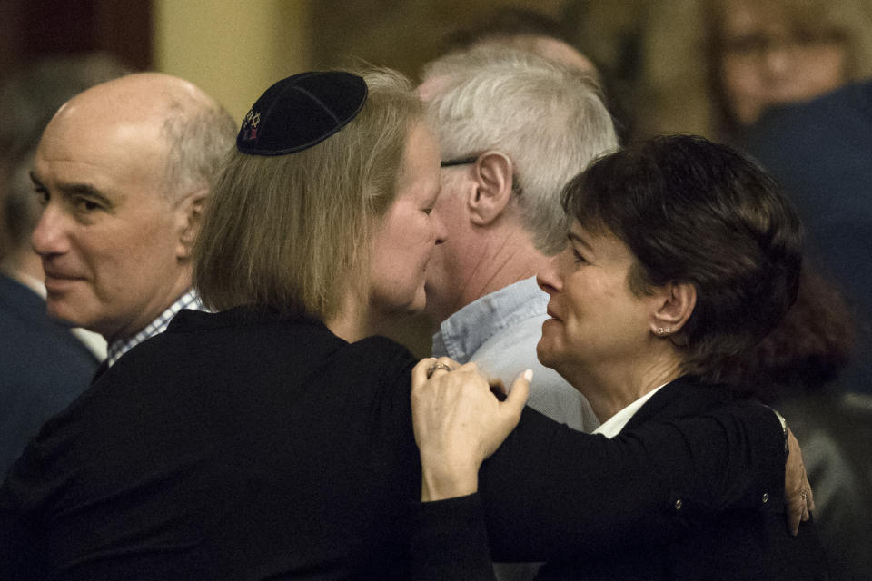 Andrea Wedner, right, who was wounded at the Pittsburgh synagogue attack that killed 11 people last year, embraces Dor Hadash Rabbi Cheryl Klein after Pennsylvania lawmakers came together in an unusual joint session to commemorate the victims of synagogue attack, Wednesday, April 10, 2019, at the state Capitol in Harrisburg, Pa. (AP Photo/Matt Rourke)