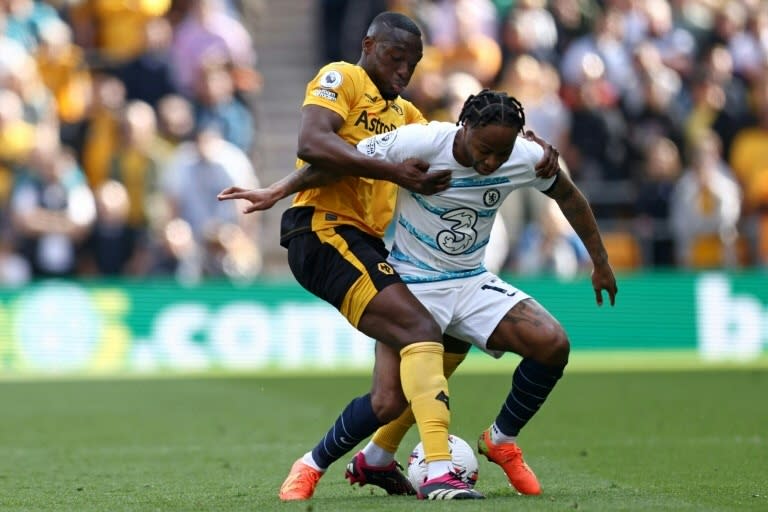 El defensor portugués de los Wolves Tote 'Toti' Gomes (L) aborda al mediocampista del Chelsea Raheem Sterling (R) en la Premier League