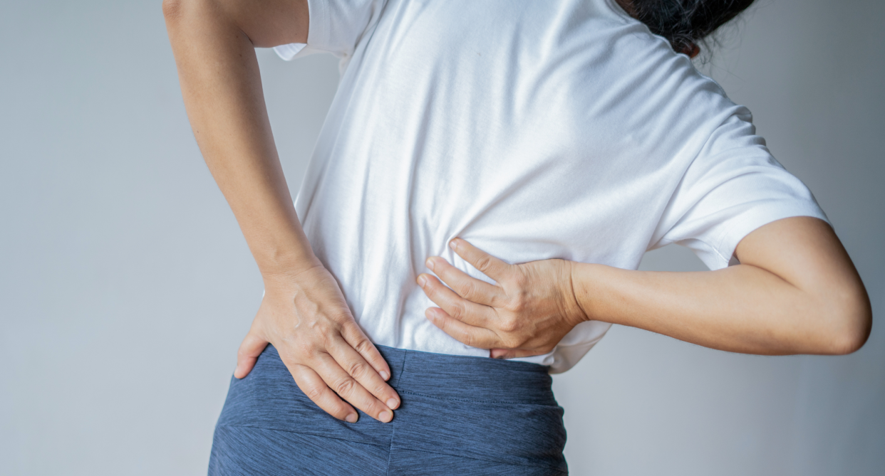 back, woman clutching lower back in pain, Today only, Amazon shoppers can save 20 per cent on the T TIMTAKBO lower back brace (Photo via Getty)