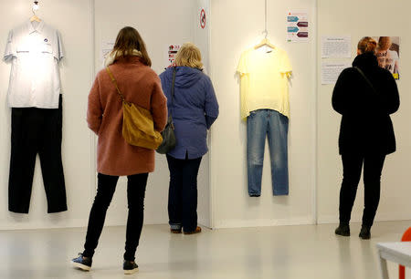 Visitors are seen at the exhibition "What Were You Wearing?" that showcases the stories of U.S. student rape victims through representations of the outfits they wore during their assault, in the Brussels district of Molenbeek, Belgium January 16, 2018. REUTERS/Francois Lenoir