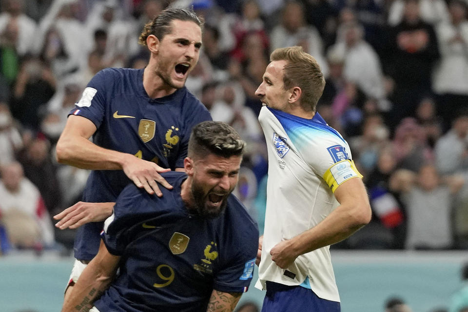 France's Adrien Rabiot, top, and France's Olivier Giroud celebrate after England's Harry Kane missed a penalty kick during the World Cup quarterfinal soccer match between England and France, at the Al Bayt Stadium in Al Khor, Qatar, Saturday, Dec. 10, 2022. (AP Photo/Frank Augstein)