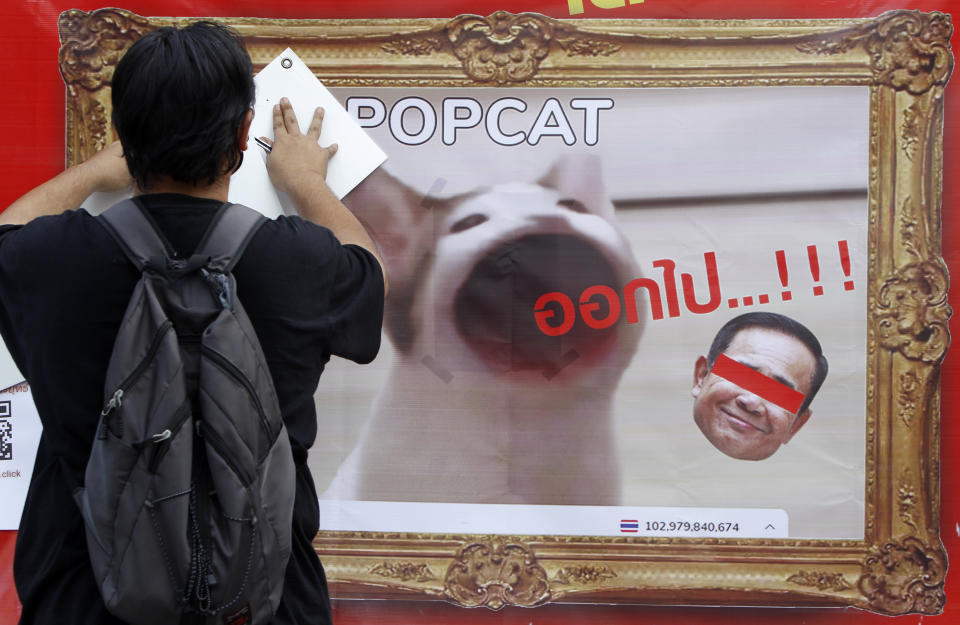 A pro-democracy protester install a poster with picture a PopCat and Thailand's Prime Minister Prayuth Chan O-Cha during the demonstration at Asoke intersection in Bangkok on September 2, 2021. Protesters demand Thailand's Prime Minister, Prayut Chan-o-cha steps down and the government be held accountable for its gross mismanagement of the Covid-19 pandemic. (Photo by Chaiwat Subprasom/NurPhoto via Getty Images) (Photo by Chaiwat Subprasom/NurPhoto via Getty Images)