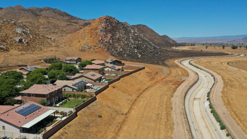 A burn scar from the Ramona Fire can be seen near homes on Yukon Drive and the Casa Loma Canal in San Jacinto, Calif., Aug, 18, 2023. The fire was in May 2023.