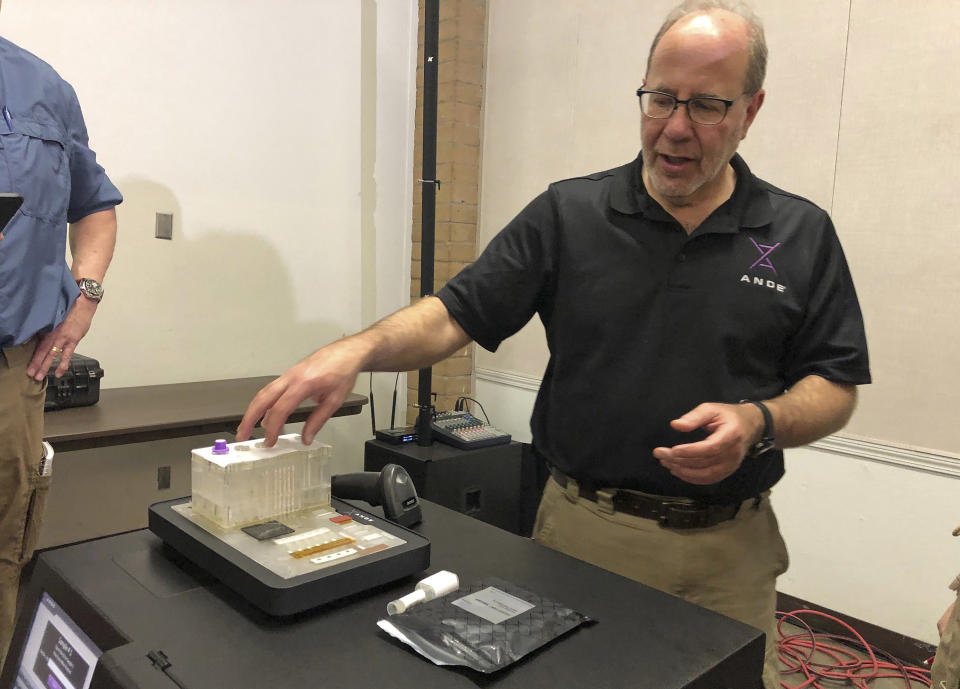 FILE - In this Nov. 16, 2018, file photo, Stephen Meer, chief information officer from ANDE, demonstrates in Chico, Calif., his company's Rapid DNA analysis system. Rapid DNA machines have helped solve rape cases in Kentucky, identified California wildfire victims and verified family connections of migrants at the U.S.-Mexico border. But Texas officials are raising concerns. (AP Photo/Sudhin Thanawala, File)