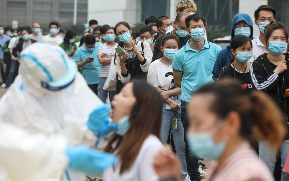 TOPSHOT - Staff members from the AOC computer monitor factory queue to be tested for the COVID-19 coronavirus in Wuhan in China's central Hubei province on May 15, 2020. - Nervous residents of China's pandemic epicentre of Wuhan queued up across the city to be tested for the coronavirus on May 14 after a new cluster of cases sparked a mass screening campaign. (Photo by STR / AFP) / China OUT (Photo by STR/AFP via Getty Images) - AFP via Getty Images