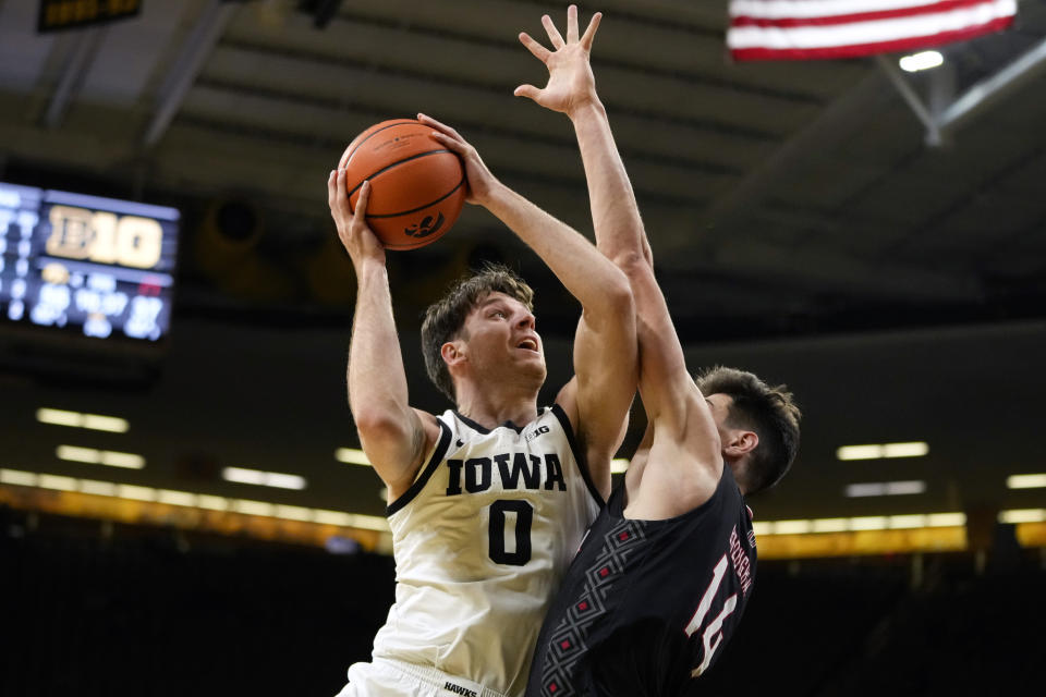 Iowa forward Filip Rebraca (0) shoots over Omaha center Dylan Brougham (14) during the second half of an NCAA college basketball game, Monday, Nov. 21, 2022, in Iowa City, Iowa. (AP Photo/Charlie Neibergall)