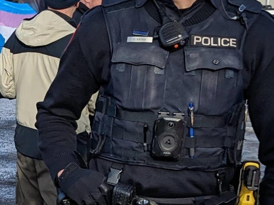 During a protest outside a drag show on Sunday afternoon, several Calgary police officers were seen wearing a pin with a horizontal blue line through it, prompting questions from the public about why the symbol is allowed. (Euan Thomson/Twitter - image credit)