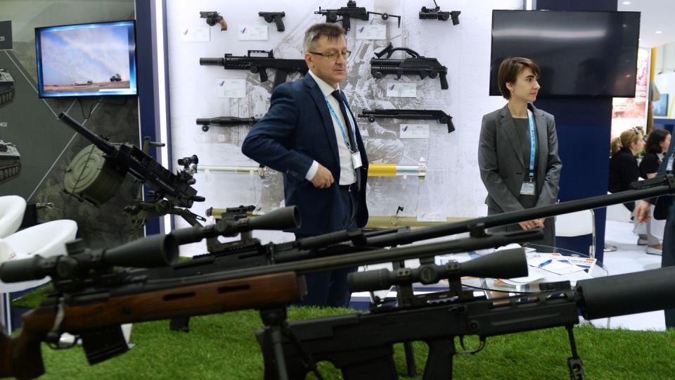 Exhibitors stand next to rifles of Russia's Rostec enterprise at a 2018 defense exhibition on the outskirts of Chennai, India. (Arun Sankar/AFP via Getty Images)