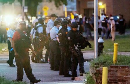 Police line up to block the street as protesters gathered after a shooting incident in St. Louis, Missouri August 19, 2015. REUTERS/Kenny Bahr