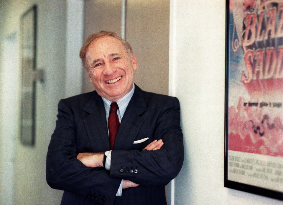 ARCHIVO – El actor y director Mel Brooks posa junto a un afiche enmarcado de su película de 1974 "Blazing Saddles" en Los Angeles el 23 de julio de 1991. Brooks publicó su libro de memorias "All About Me!: My Remarkable Life in Show Business". (Foto AP/Nick Ut, archivo)