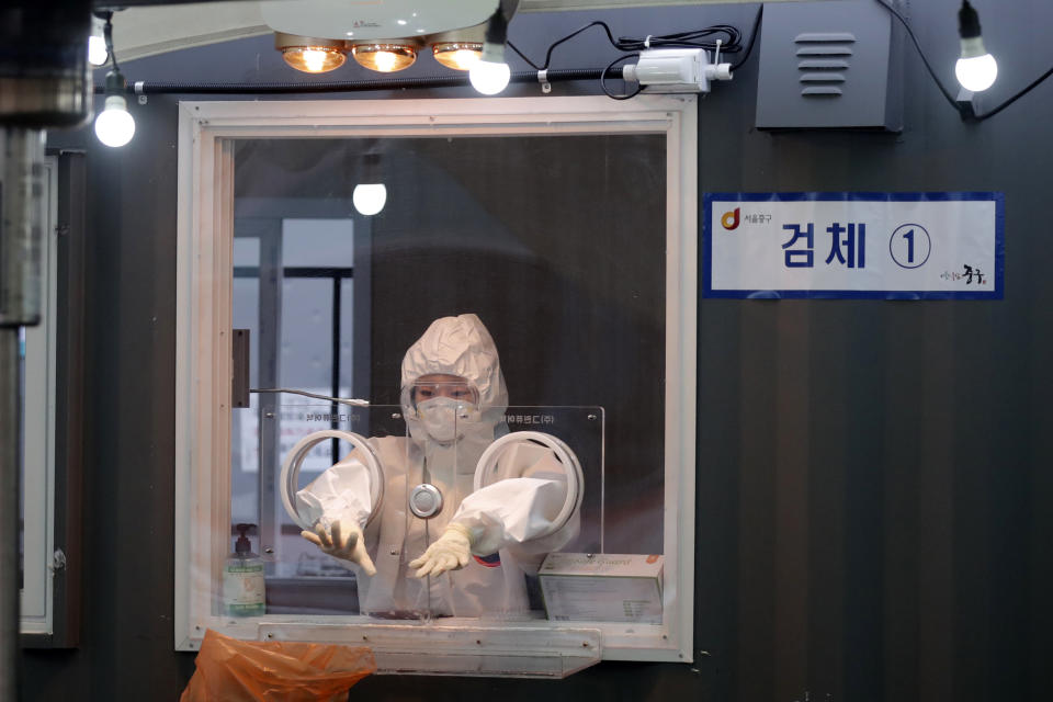 A medical worker wearing protective gear prepares to take a sample at coronavirus testing site in Seoul, South Korea, Monday, Jan. 11, 2021. (AP Photo/Lee Jin-man)