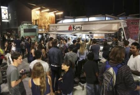 People stand in line to order from food trucks during the monthly first Friday event on Abbot Kinney Boulevard in Venice, California November 7, 2014. REUTERS/Jonathan Alcorn