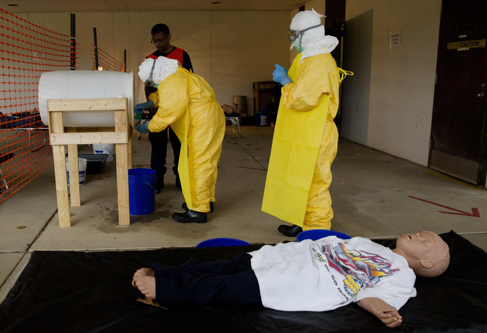 Licensed clinicians and Lt. Commander Medical Officer for the CDC, Satish Pillai (center), practice sanitizing their hands after drawing blood from a simulated patient on Monday, Oct. 6, 2014, in Anniston, Ala. The Centers for Disease Control and Prevention (CDC) has developed an introductory training course for licensed clinicians. According to the CDC, the course is to ensure that clinicians intending to provide medical care to patients with Ebola have sufficient knowledge of the disease. (AP Photo/Brynn Anderson)