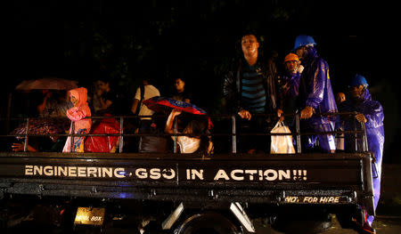 Residents who evacuated their homes due to Typhoon Haima ride on a government truck as they are transported to an evacuation centre in San Fernando, la Union in northern Philippines, October 19, 2016. REUTERS/Erik De Castro