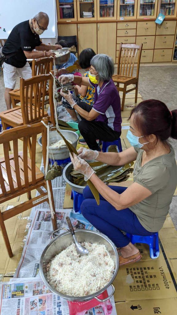 台南市家庭關懷協會志工動手包粽子，每戶一個便當搭配兩粒粽子，為社區獨老賀節。 （記者陳俊文攝）