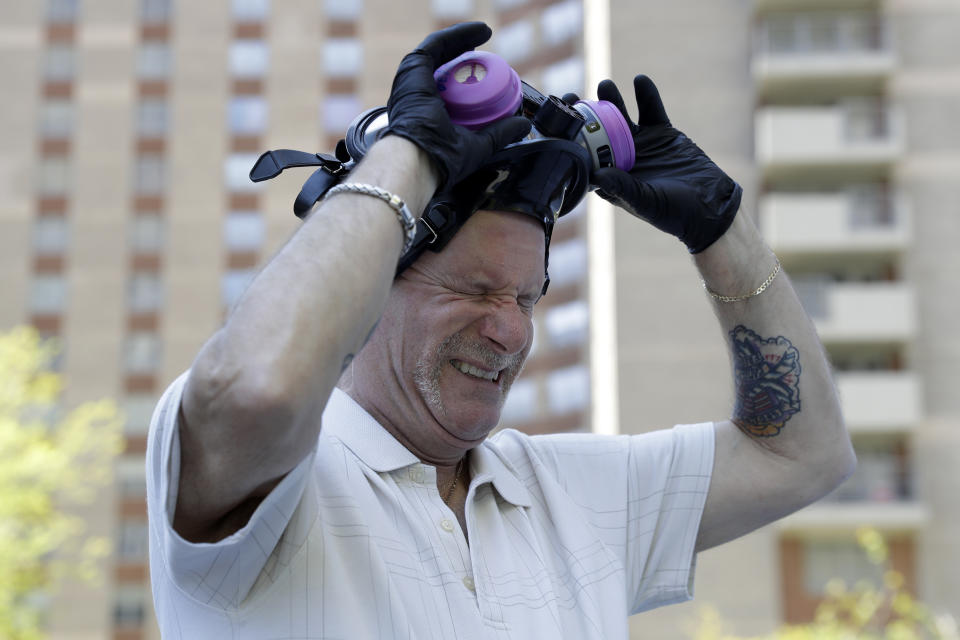 Safety Director Tony Barzelatto reacts as he pulls off his protective mask after disinfecting parts of a building in Co-op City in the Bronx borough of New York, Wednesday, May 13, 2020. Regular cleanings occur throughout the common areas of the buildings while the heavy disinfecting occurs in response to specific incidents, in this case reports of two coronavirus cases on the same floor. Within the Bronx, almost no place has been hit as hard as Co-op City. (AP Photo/Seth Wenig)