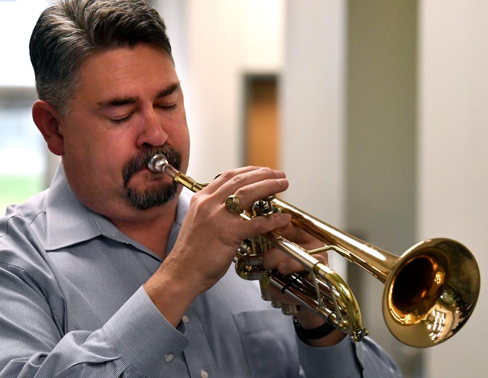 Jay Lester, Executive Director of Fine Arts for AISD, plays Taps during the dedication of the AISD Veterans Memorial Wall at Dyess Elementary School Friday.