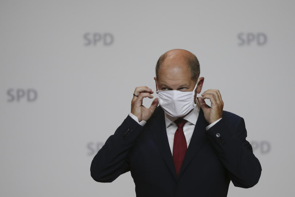 German Finance Minister Olaf Scholz fixes his face mask after a news conference in Berlin, Germany, Monday, Aug. 10, 2020. Olaf Scholz announces that he will run for the for the Social Democratic Party as chancellor candidate at next year's general elections in Germany.(AP Photo/Markus Schreiber)