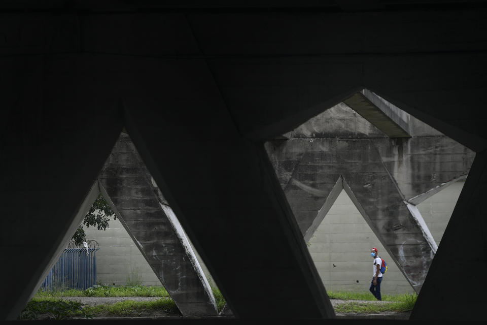 A man wearing a protective face mask amid the new coronavirus pandemic, walks through a tunnel in Caracas, Venezuela, Tuesday, July 28, 2020. (AP Photo/Matias Delacroix)