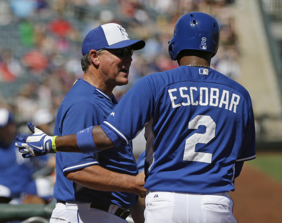 El manager de los Reales de Kansas City Ned Yost felicita al venezolano Alcides Escobar después de anotar a los Rangers de Texas en la segunda entrada del juego de pretemporada del sábado 22 de marzo de 2014, en Surprise, Arizona. (Foto AP/Darron Cummings)