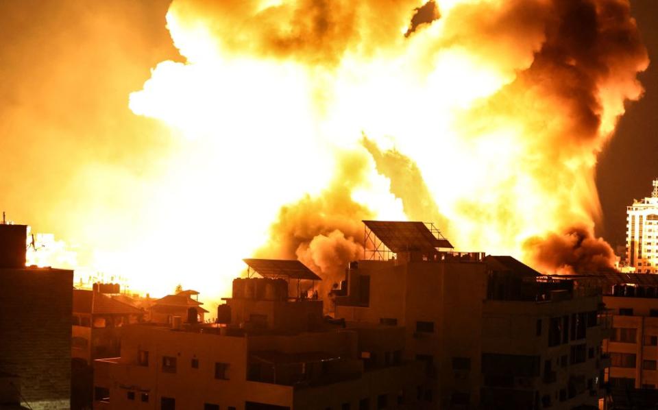 A ball of fire explodes above buildings in Gaza City as Israeli forces shell the Palestinian enclave.