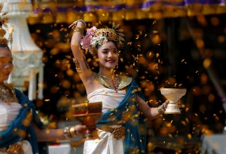 Local women perform in traditional dresses at a ceremony for members of the Wild Boars soccer team, during their return to the Tham Luang caves where they were trapped in a year ago, in Chiang Rai