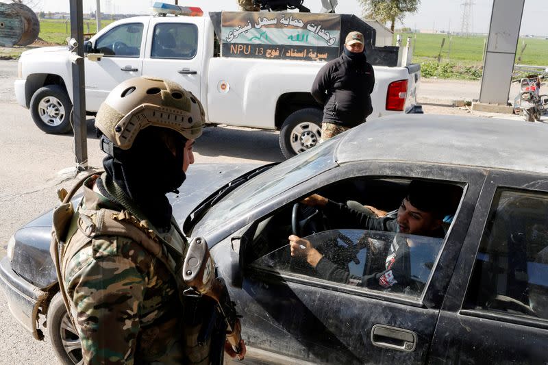 FILE PHOTO: Christian militia check a vehicle at a gate of Christian town of Hamdaniya