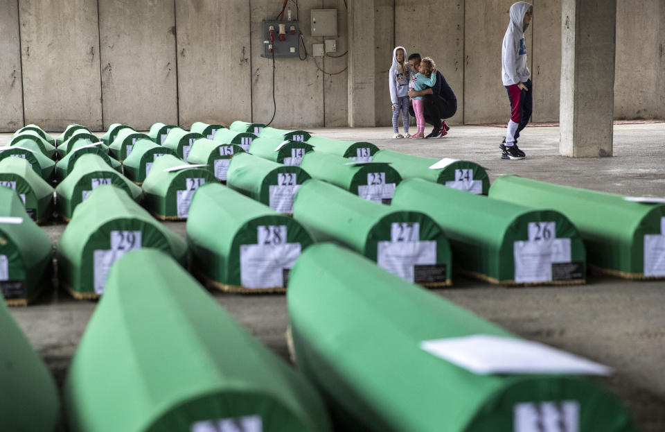 Relatives inspect coffins prepared for burial in Potocari near Srebrenica, Bosnia, Wednesday, July 10, 2019. The remains of 33 victims of Srebrenica massacre will be buried on July 11, 2019, 24 years after Serb troops overran the eastern Bosnian Muslim enclave of Srebrenica and executed some 8,000 Muslim men and boys, which international courts have labeled as an act of genocide. (AP Photo/Darko Bandic)
