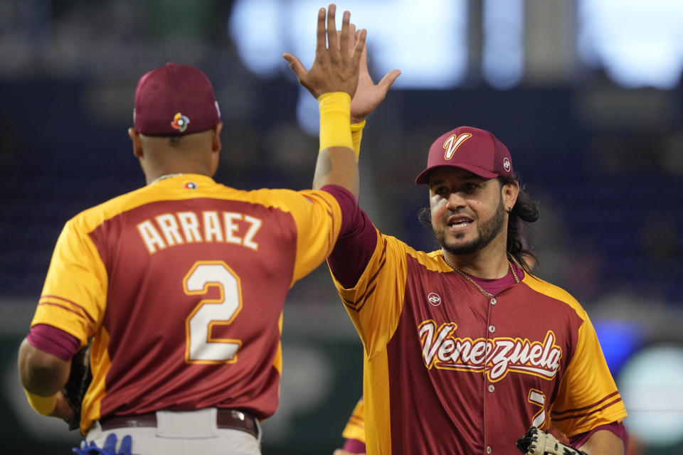 Venezuela first baseman baseman Eugenio Suarez (7) and Luis Arraez (2) celebrate after a double play during the fifth inning of a World Baseball Classic game against Israel, Wednesday, March 15, 2023, in Miami. (AP Photo/Marta Lavandier)