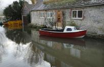 A boat floats in front of a house during flooding at Bury near Pulborough, West Sussex. Parts of the United Kingdom are entering a third week of flooding and stormy conditions. (Reuters)