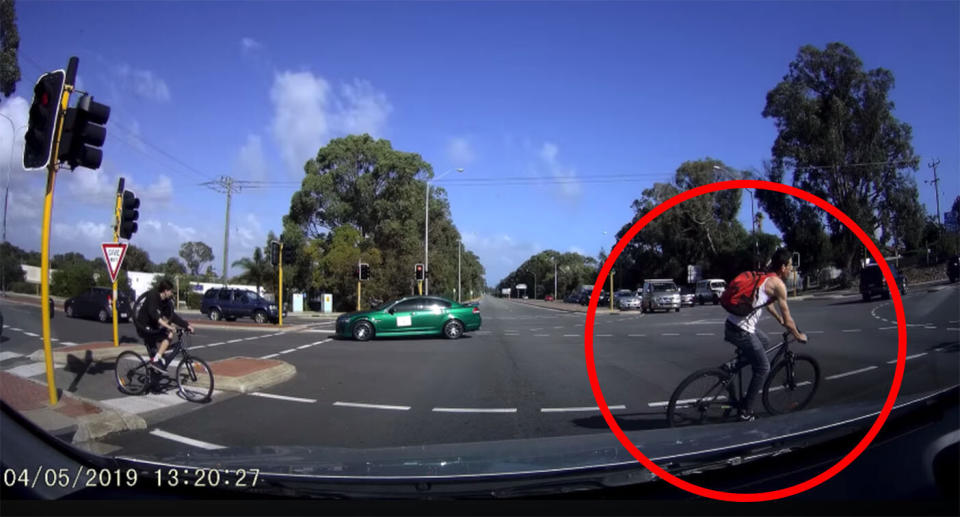 The cyclist, who is not wearing a helmet, is seen cutting across lanes of stopped traffic. Source: Dash Cam Owners Australia / Facebook