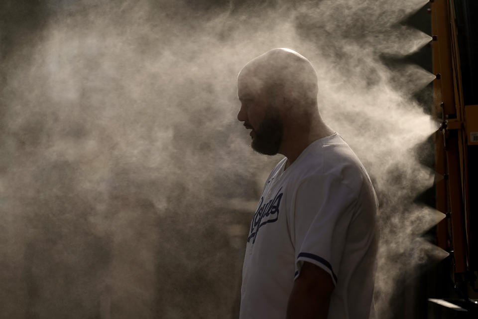 A man cools off in a mister at Kauffman Stadium as temperatures approach 100 degrees fahrenheit before a baseball game between the Kansas City Royals and the Cleveland Guardians, Wednesday, June 28, 2023, in Kansas City, Mo. (AP Photo/Charlie Riedel)