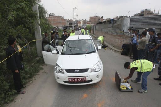 Nepalese crime officers examine the car in which a Supreme Court judge was shot in Kathmandu on Thursday. Gunmen on a motorbike shot and killed the judge, sparking fears of lawlessness amid a political vacuum in the Himalayan country