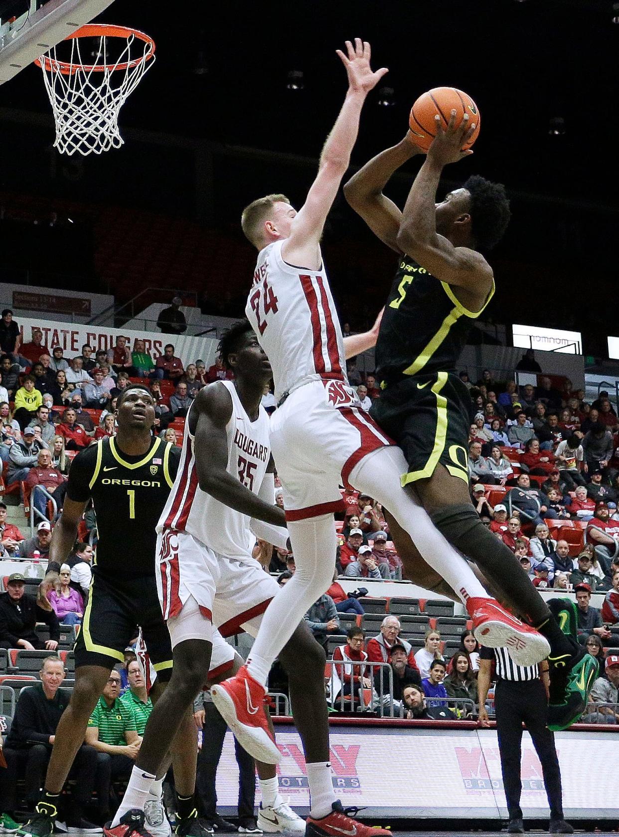 Oregon guard Jermaine Couisnard (5) shoots while defended by Washington State guard Justin Powell (24) during the second half of the game Sunday, Feb. 19, 2023, in Pullman, Wash.