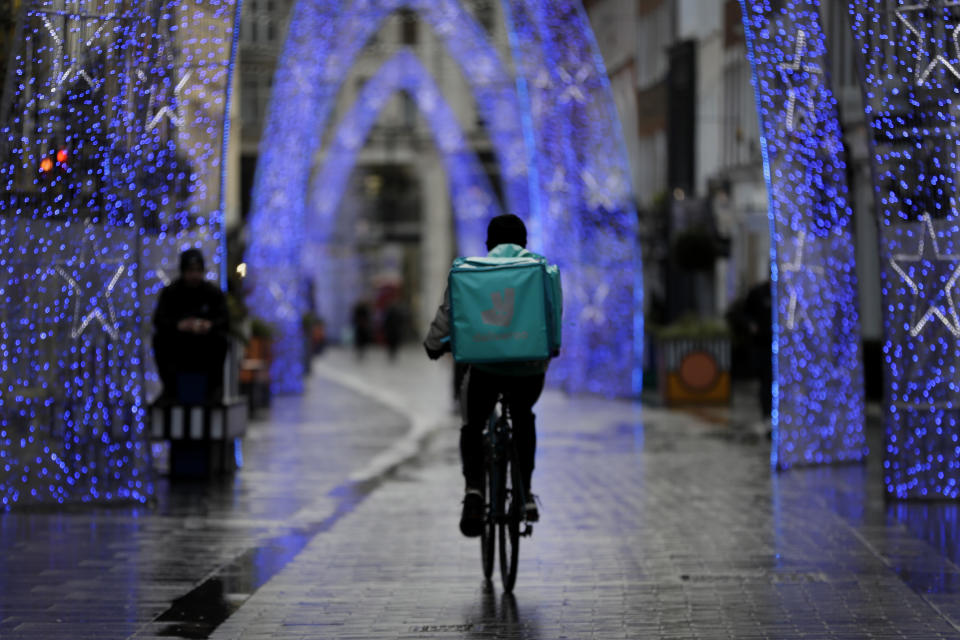 Un repartidor en bicicleta recorre la calle South Molton de Londres, inusualmente tranquila, el miércoles 23 de diciembre de 2020. (AP Foto/Kirsty Wigglesworth)