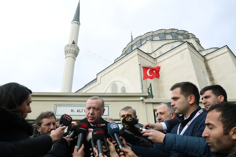 Turkish President Erdogan talks to journalists in front of a mosque as he leaves friday prayers in Istanbul