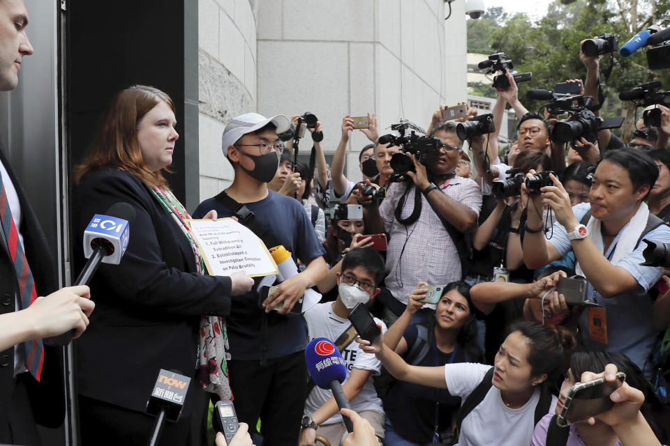 Journalists film a protester passing a letter to a representative from the British Consulate during a protest in Hong Kong, Wednesday, June 26, 2019. Hong Kong activists opposed to contentious extradition legislation on Wednesday called on leaders of the U.S., the European Union and others to raise the issue with Chinese President Xi Jinping at this week's G-20 summit in Japan. (AP Photo/Kin Cheung)