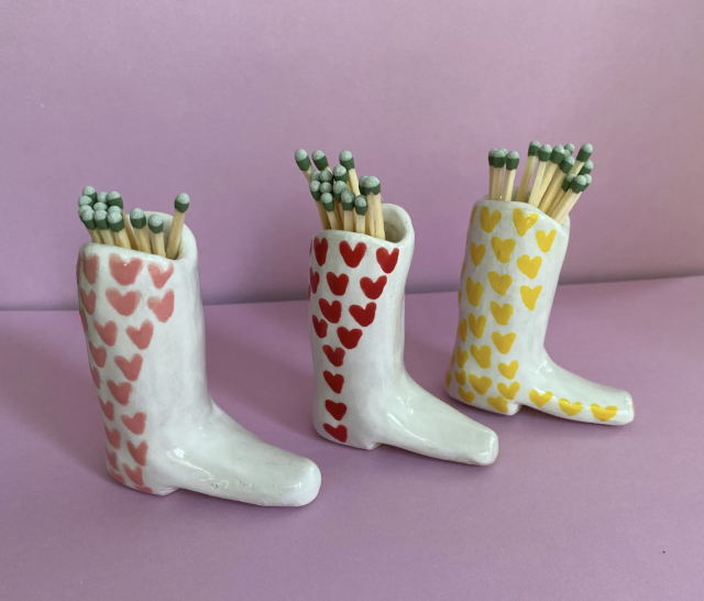 Cowboy Boot Match Strikers in white with yellow, pink and red hearts on pink background (photo via Etsy)