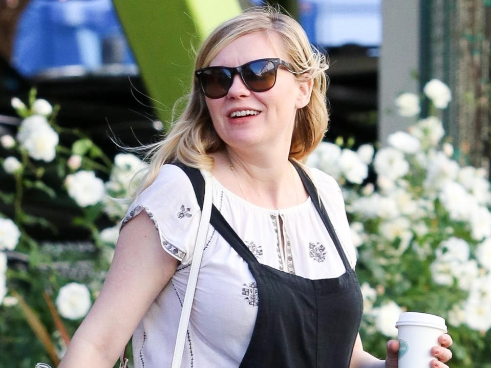 Kirsten Dunst dressed her growing baby bump in a pair of causal black overalls while stepping out with a friend on Thursday.