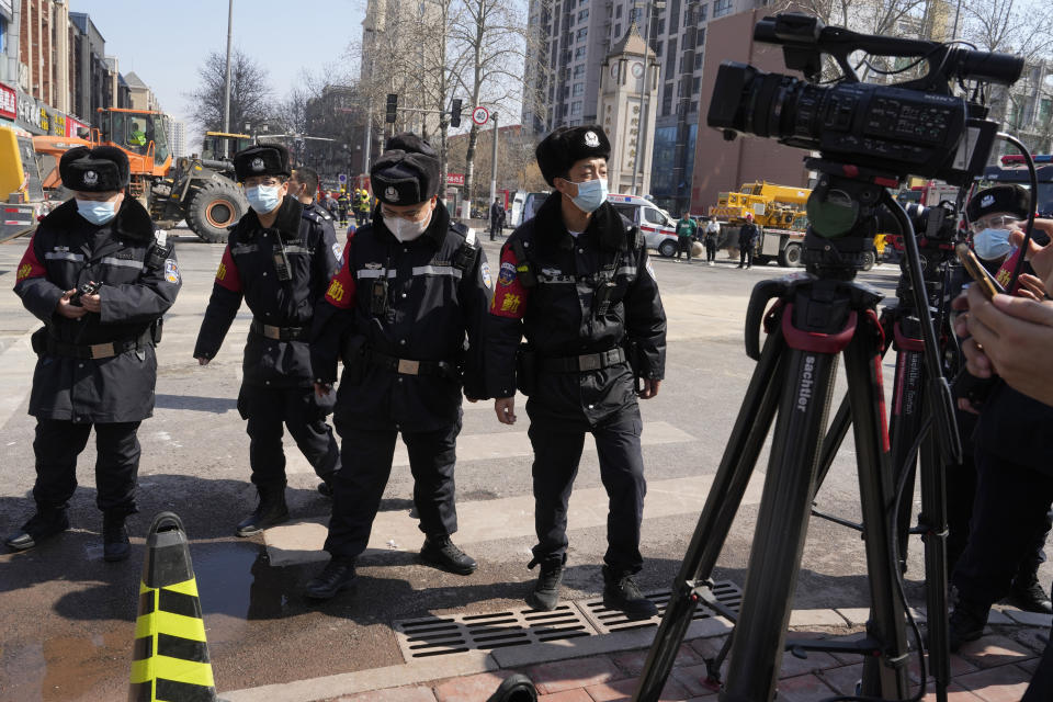 Chinese police officers prepare to push journalists away from the scene of an explosion in Sanhe city in northern China's Hebei province on Wednesday, March 13, 2024. City officials in eastern China have apologized to local journalists after authorities were shown pushing them and trying to obstruct reporting from the site of a deadly explosion, in a rare acknowledgment of state aggression against journalists. (AP Photo/Ng Han Guan)