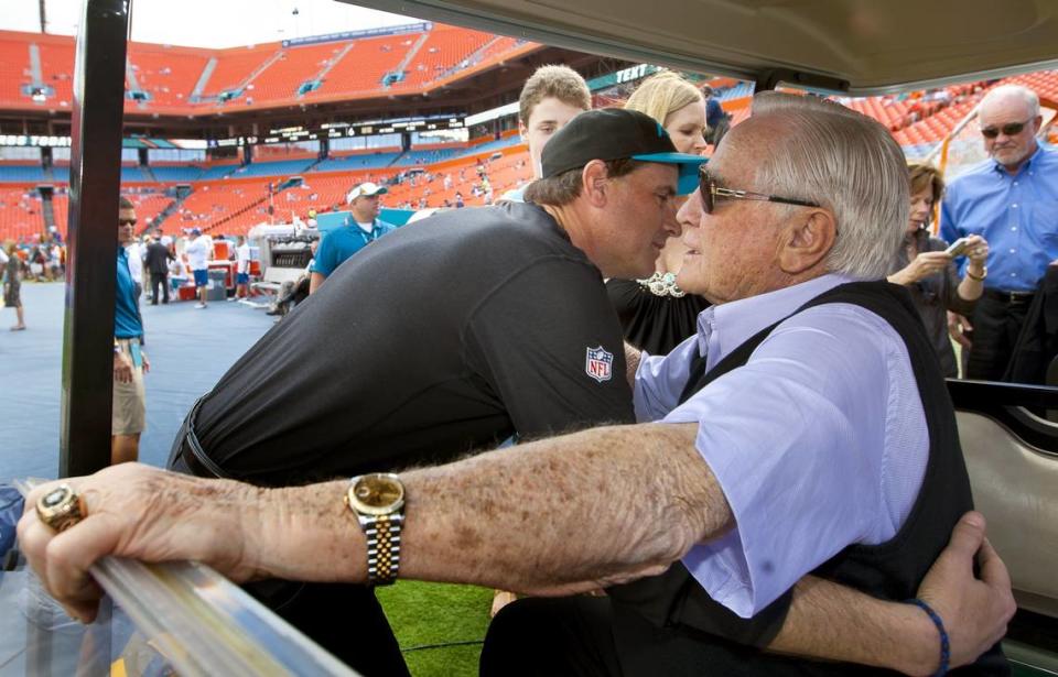 Mike Shula, then the Carolina Panthers’ offensive coordinator, hugs his dad Don Shula on the sideline before a 2013 game between the Miami Dolphins and the Carolina Panthers.