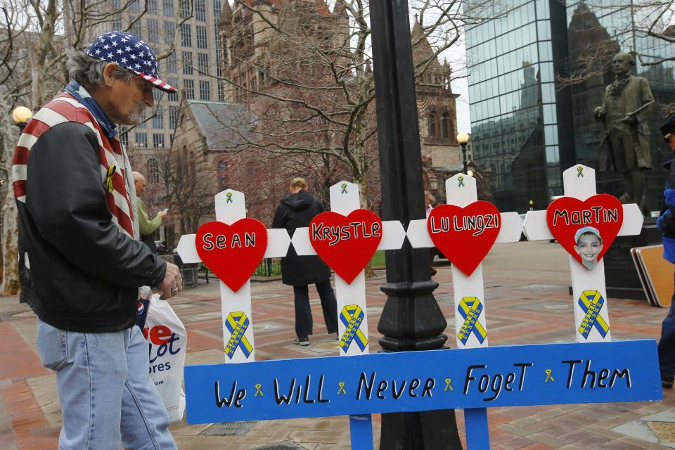 Kevin Brown puts up a hand made memorial for victims of the 2013 Boston Marathon bombings near the race's finish line in Boston, Massachusetts April 15, 2014, on the one year anniversary of the bombings. REUTERS/Brian Snyder (UNITED STATES - Tags: SPORT ATHLETICS DISASTER)