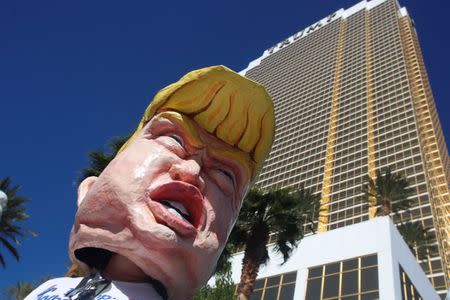 A protestor wears a head made to look like U.S. Presidential candidate Donald Trump at the Wall of Tacos demonstration in front of the Trump International Hotel Las Vegas before the last 2016 U.S. presidential debate in Las Vegas, Nevada, U.S., October 19, 2016. REUTERS/Jim Urquhart