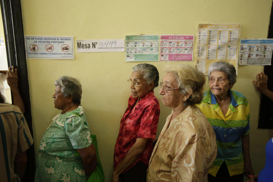 Women wait in a line to cast their vote at a polling station during general election in Panama City, Sunday, May 4, 2014. Panamanians are choosing President Ricardo Martinelli's successor in a three-way dogfight marked more by ugly personality clashes than any deep disagreements over the way forward for Latin America's standout economy. (AP Photo/Arnulfo Franco)