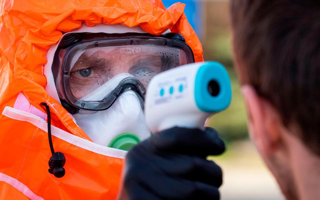 A Polish health official checks the temperature of returning Poles crossing the Polish-German border from the eastern German town of Frankfurt - AFP